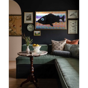 Nekol’s Fish #2 oil painting in a home interior: A single, surreal black fish floats across a vibrant, layered background of abstract, wave-like colors