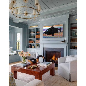 Nekol’s Fish #2 oil painting in a home interior: A single, surreal black fish floats across a vibrant, layered background of abstract, wave-like colors