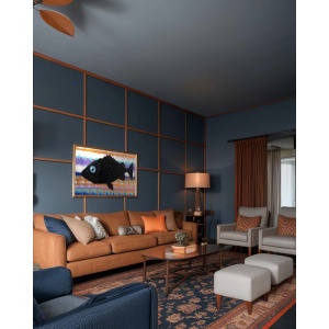 Nekol’s Fish #2 oil painting in a home interior: A single, surreal black fish floats across a vibrant, layered background of abstract, wave-like colors