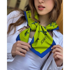 Blue butterfly silk scarf styled around the neck, showcasing lime and azure pattern.