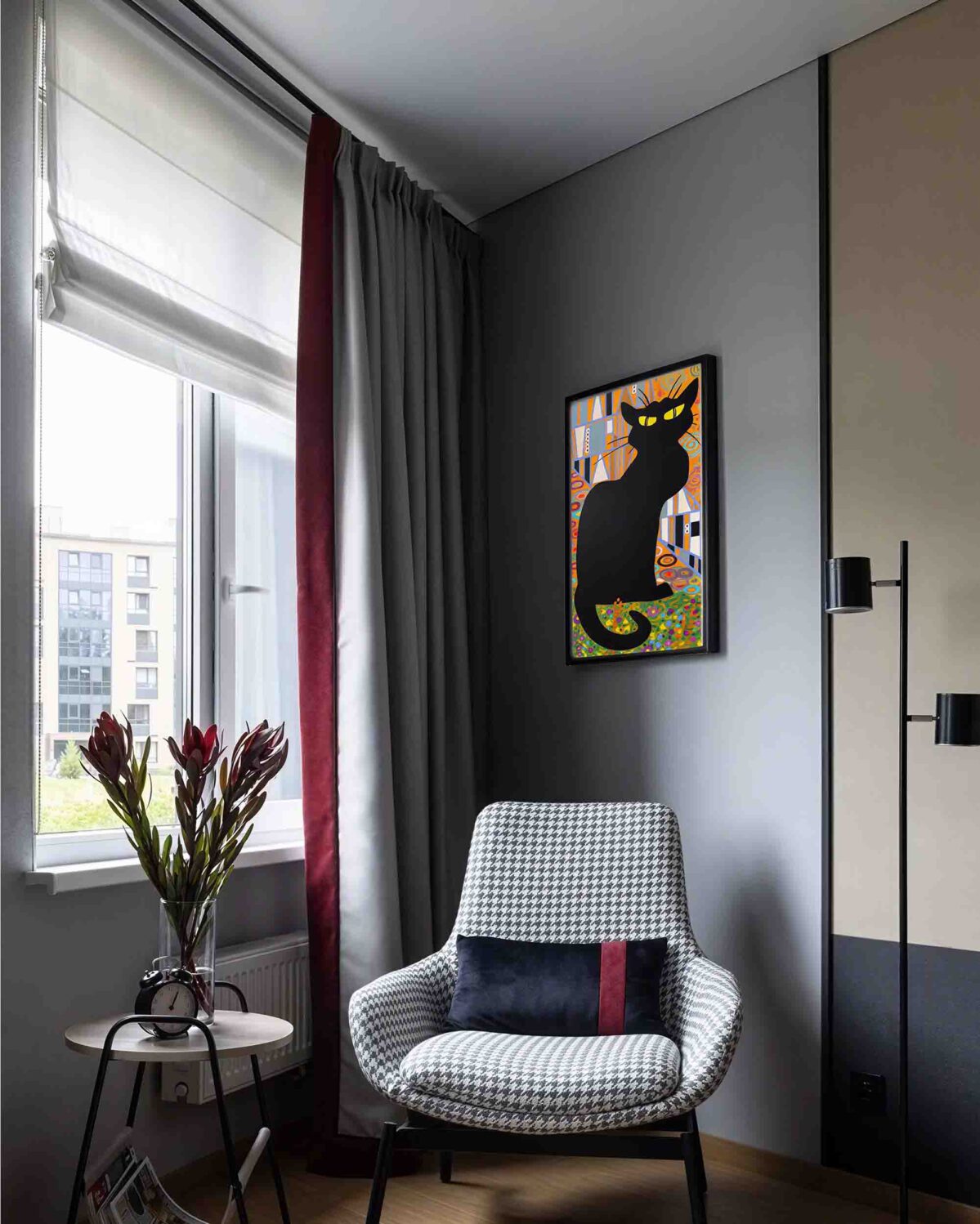 chat noir oil painting displayed in modern interior with armchair
