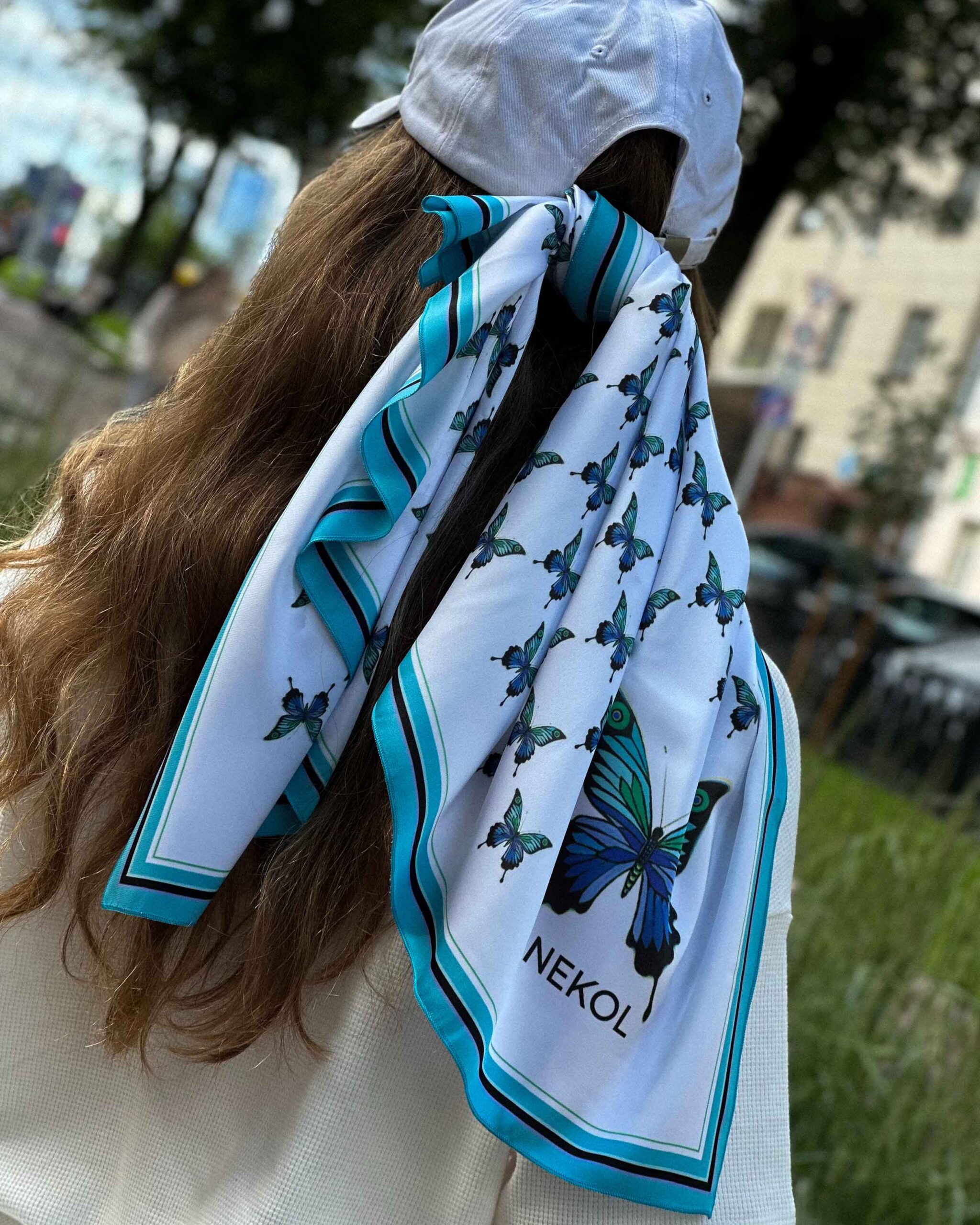 Blue butterfly silk scarf tied on hair in outdoor street style