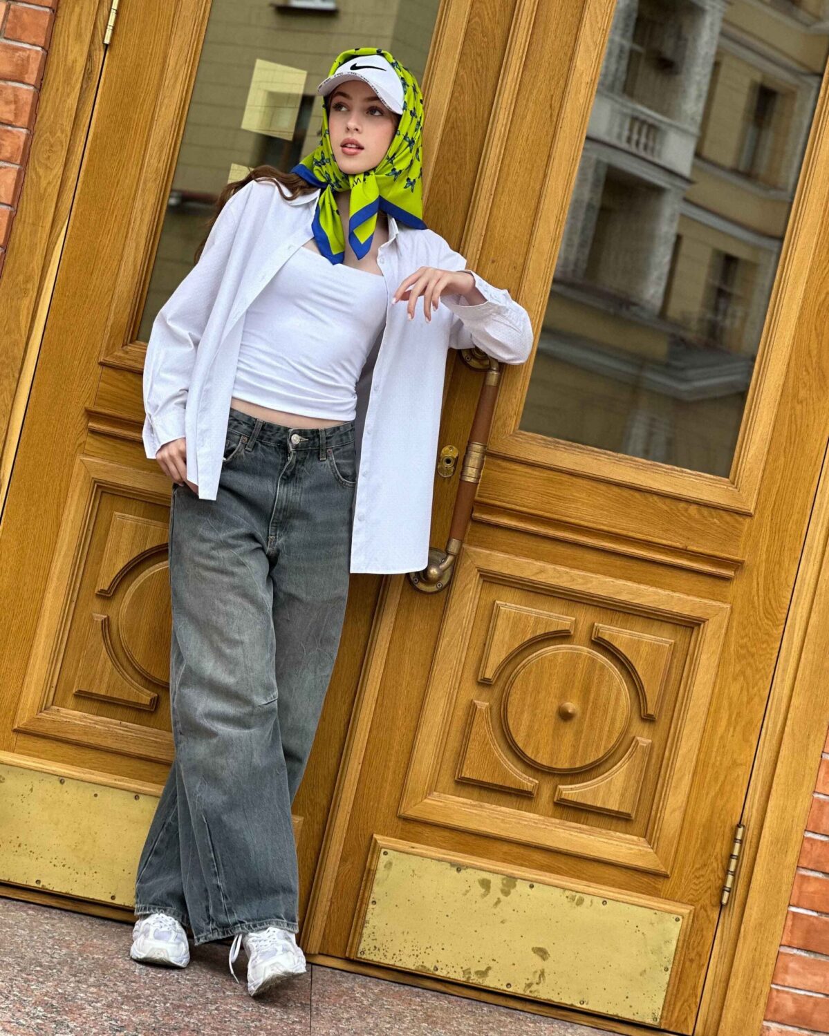 Blue butterfly silk scarf worn as a headscarf with vibrant lime and blue pattern.