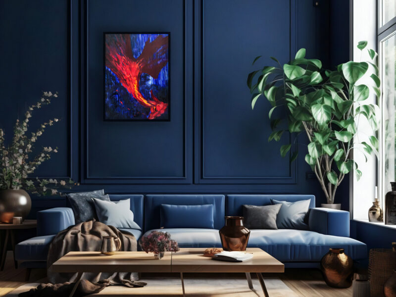 Nekol "Dragon's Fall" oil painting in elegant interior. Vibrant red and orange brushstrokes on deep blue background in black frame. Displayed in modern living room with blue velvet sofa, wooden coffee table, decorative vases, and plants. Gallery-quality original artwork.